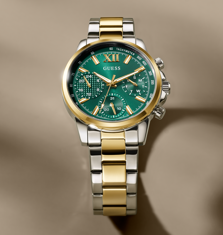 Two-tone gold and silver watch with green dial on a beige background