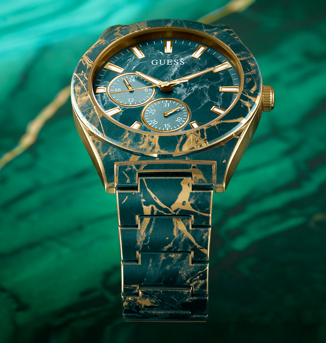 Gold and green marbled watch with 'GUESS' branding on a green background