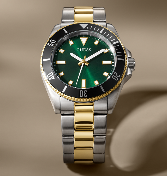 Wristwatch with green dial and gold and silver band on beige background GW0968G4