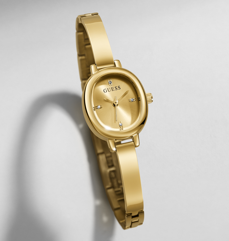 Gold-tone women's wristwatch with an oval dial, matching metal bracelet, and small crystal hour markers on a light gray background.
