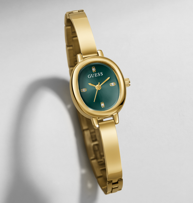 A gold-tone women's wristwatch with an oval green dial and matching green bezel, shown on a light gray background with a soft shadow.