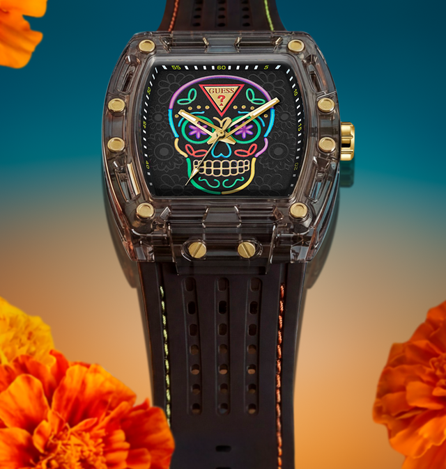 A luxury watch with a transparent smoky case, gold-tone screws, and a black strap. The dial features a colorful, vibrant sugar skull graphic with neon pink, green, blue, and yellow details.