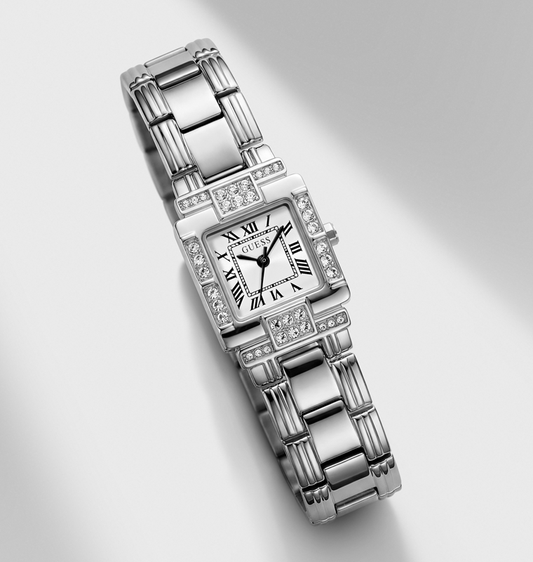 A silver-toned stainless steel watch with a rectangular bezel and link bracelet, accented with clear crystals, on a light gray background with a soft shadow.