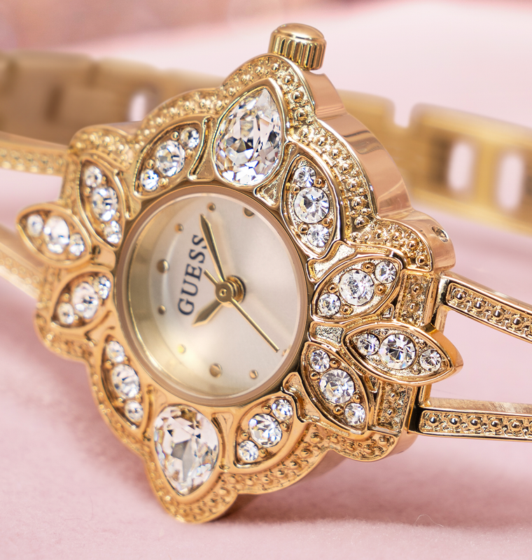 womens gold bangle watch with floral stone dial on pink background