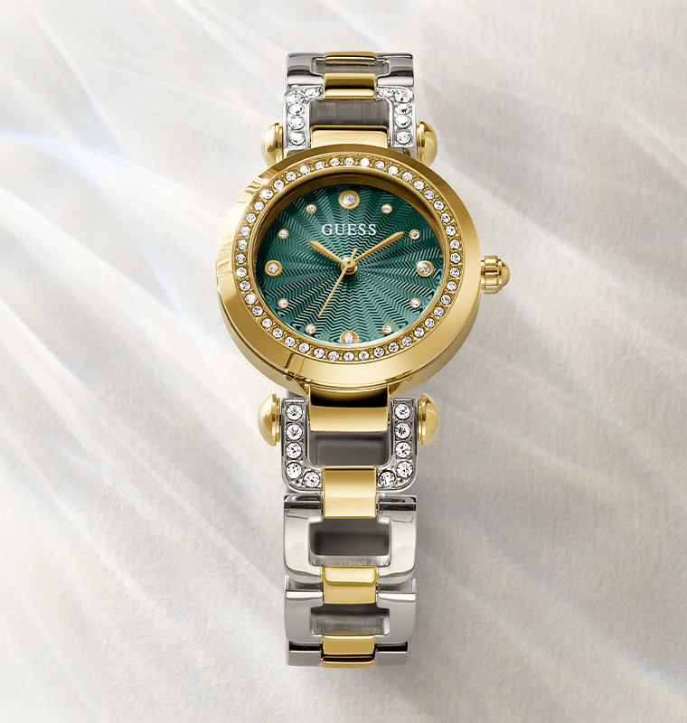 Gold and silver watch with green face on a white fabric background gw0869l1