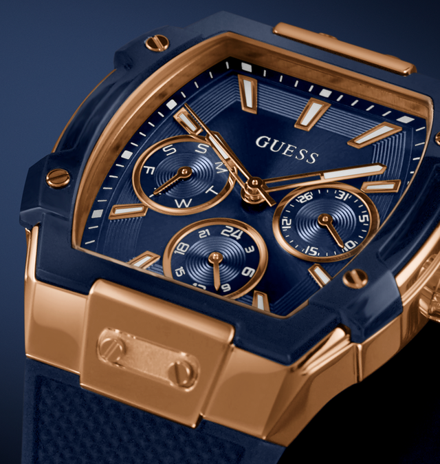 Blue and gold Guess watch with detailed face on a dark background GW0956G4