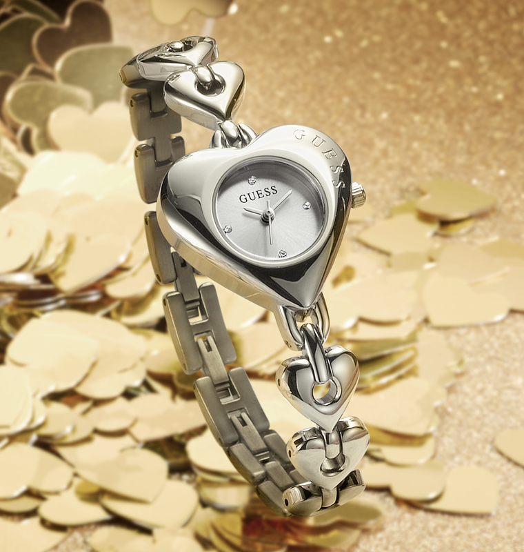 Womens silver GUESS Watch with heart shaped case on a gold background
