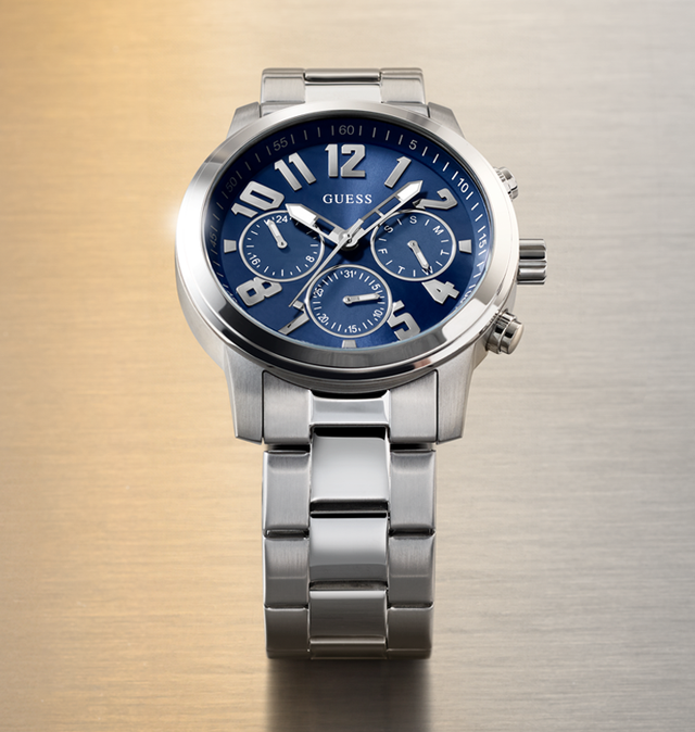 Silver watch GW1006G1 with a blue face on a textured gold and silver background