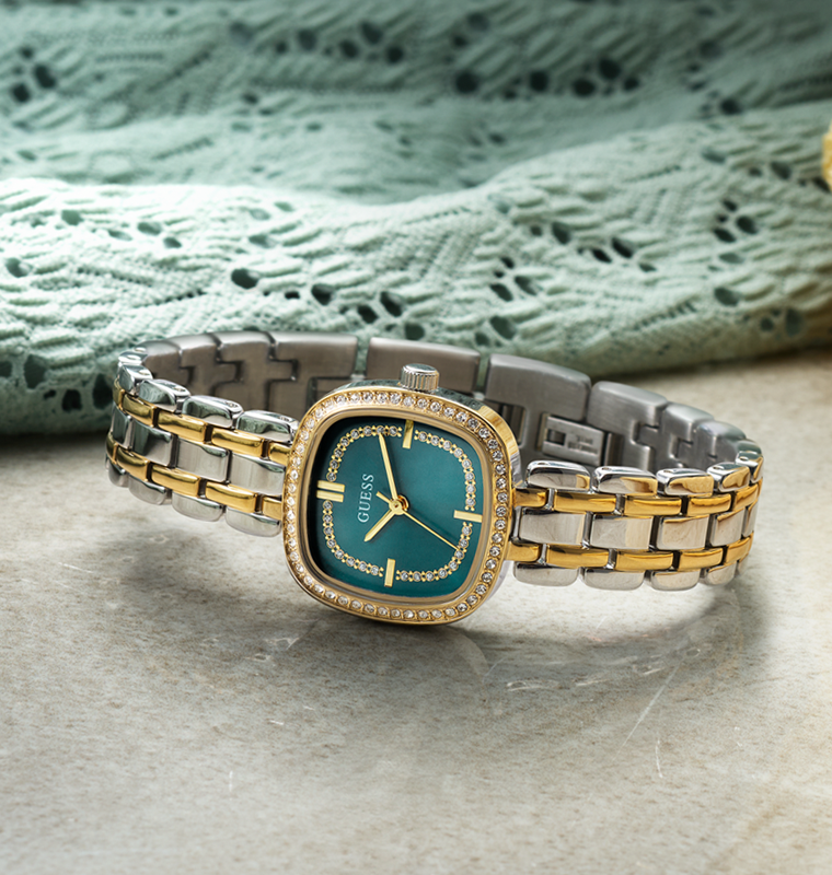 Two-tone watch with a green face on a textured surface