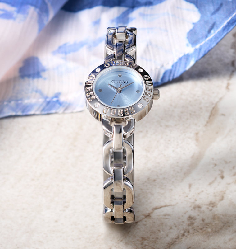 Silver Guess watch with a blue face on a marble surface