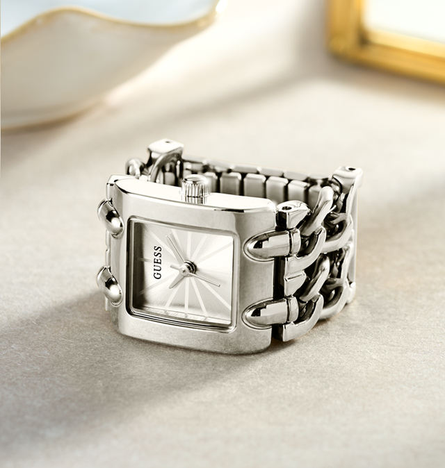 Silver Guess watch ring with chain design on a light background