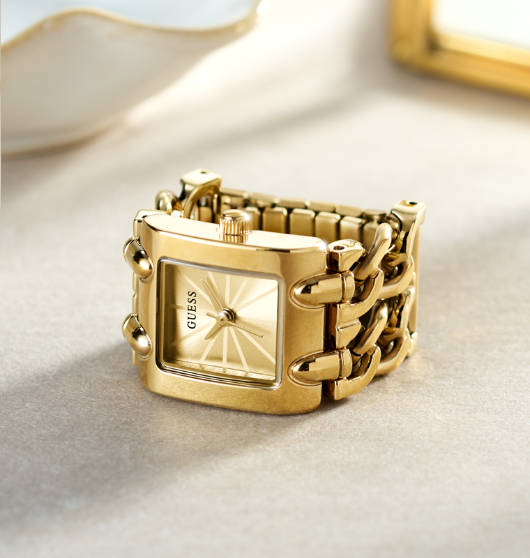 Gold chain-link ring watch on a light background