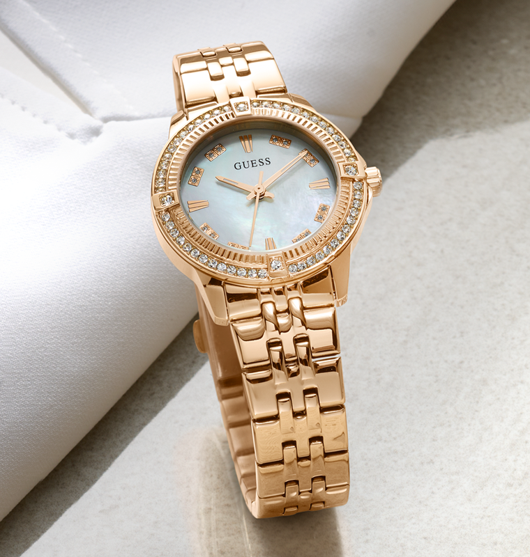 Rose gold watch with gemstone accents on a light background