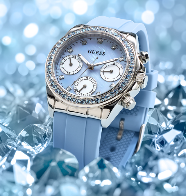 Blue Guess GUESS Ladies Ice Blue Silver Tone Analog Watch with Swarovski ReCreated™ crystals with gemstone accents on a blue gemstone background