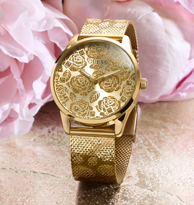 Gold watch with floral design on a pink floral background