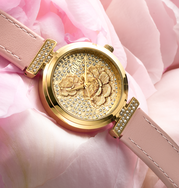Gold watch with floral design on a pink floral background