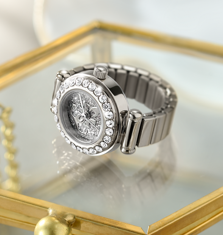 Silver watch ring with gemstone accents on a reflective surface
