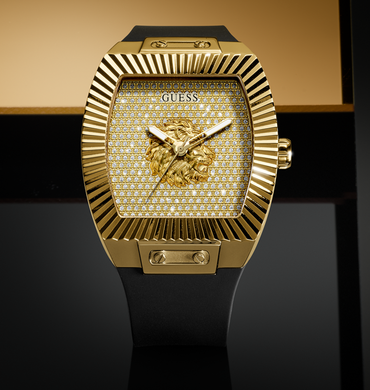 Gold watch with lion emblem and 'GUESS' branding on a black background