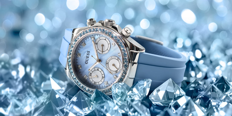 Silver Swarovski watch with blue strap on a background of blue crystals