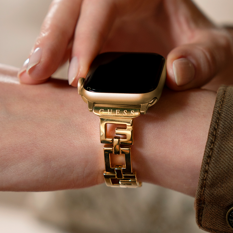 Wrist wearing an Apple Watch Band with a guess logo