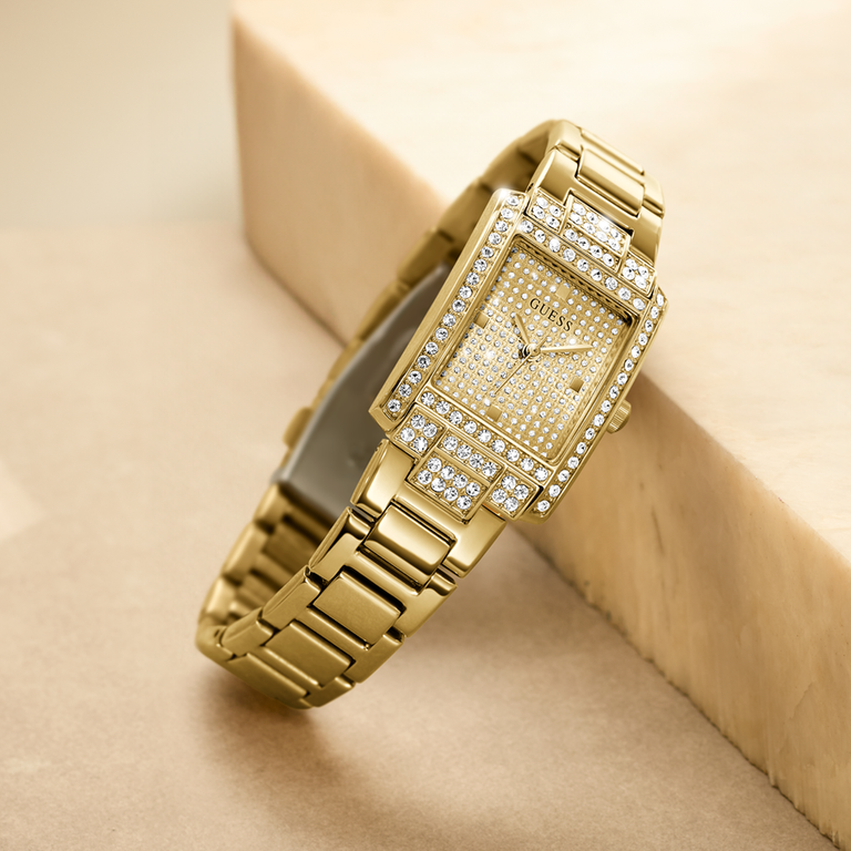Gold wristwatch with diamond accents on a beige background