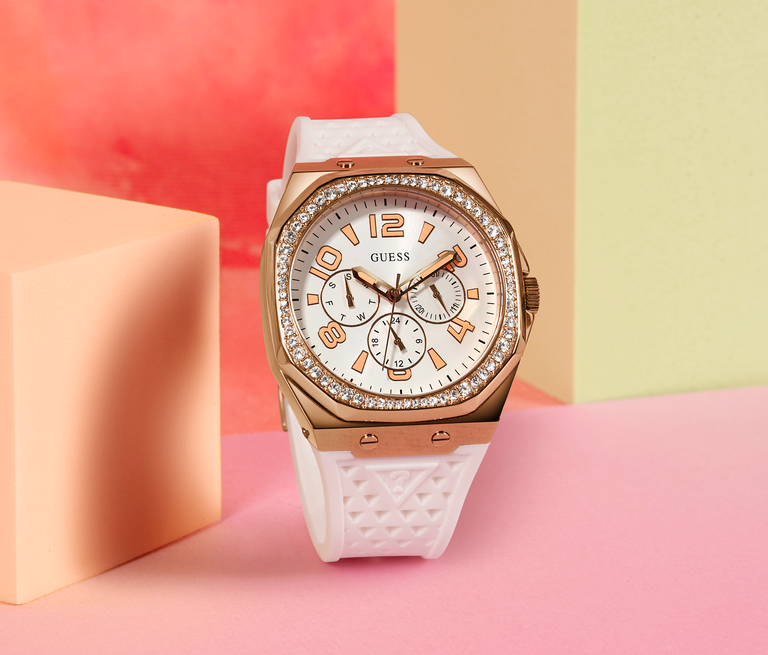 white watch with rose gold crown on peach background