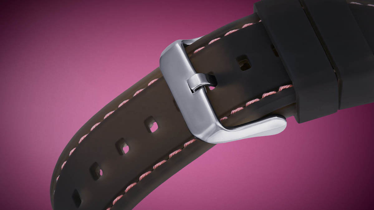 Close-up of a black watch strap with pink stitching on a purple background