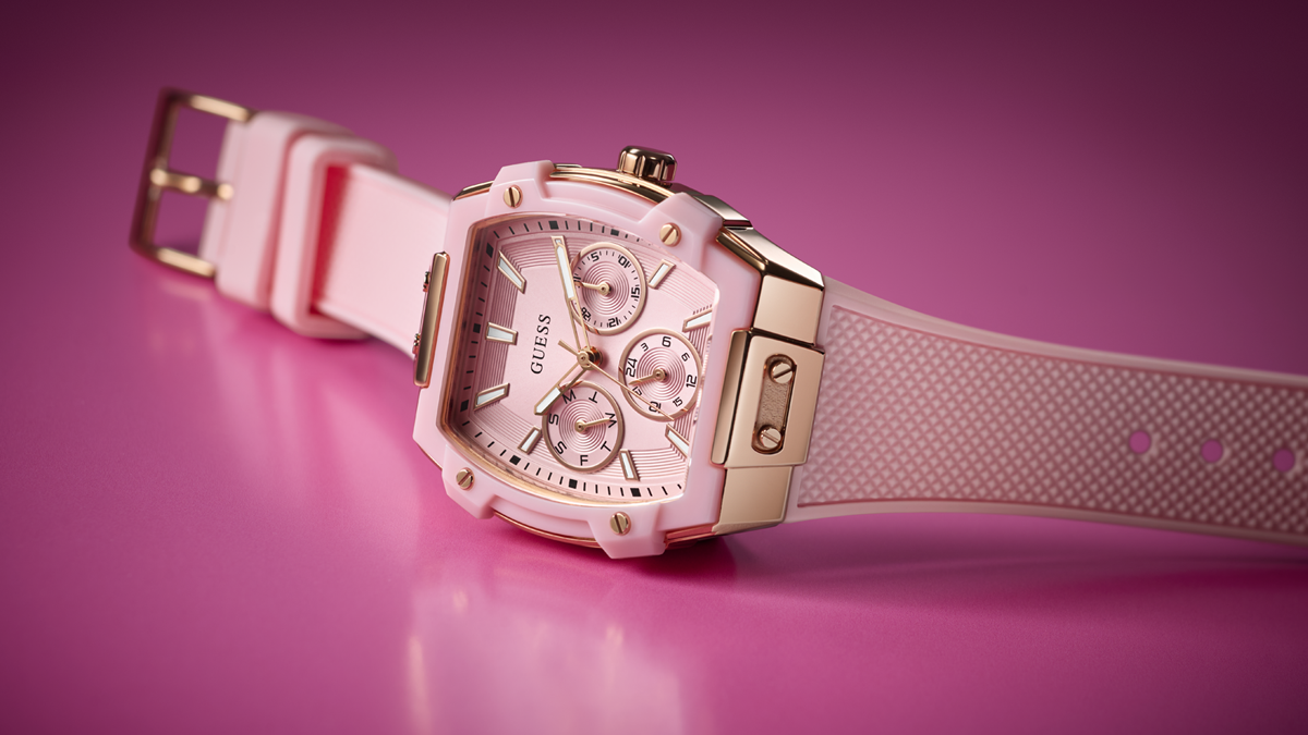 Pink watch with gold accents on a pink background