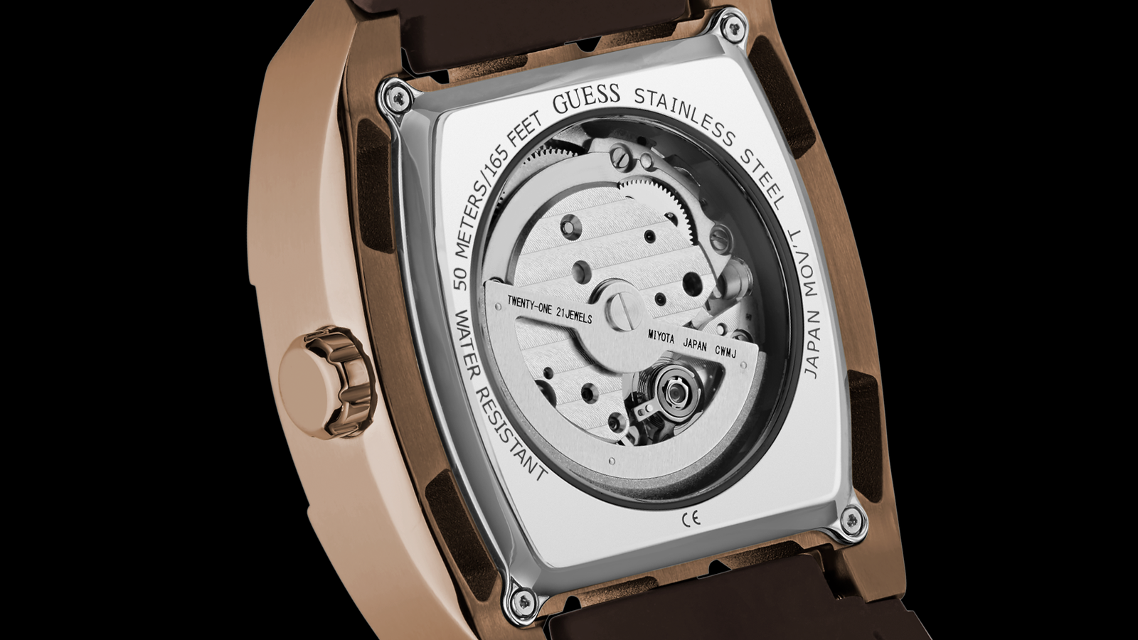 Close-up of a Guess watch mechanism with visible branding on a black background
