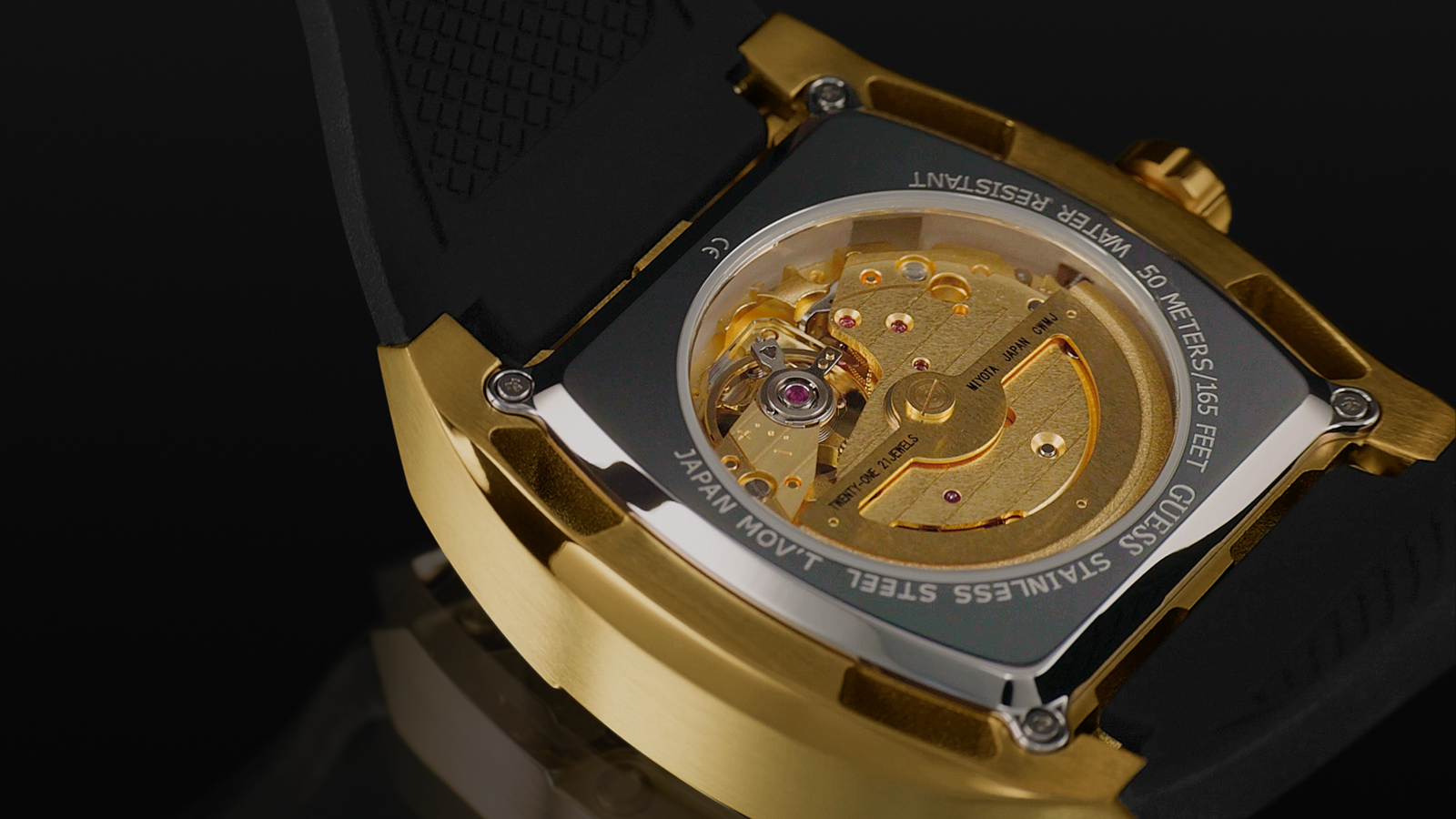 Close-up of a gold and silver watch mechanism on a black background