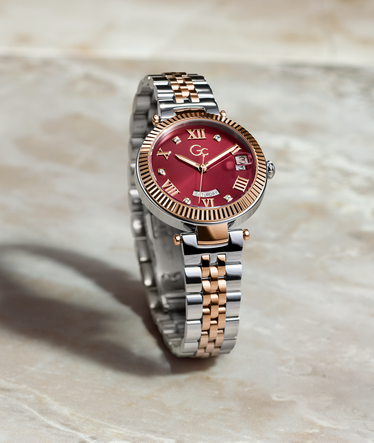 red dial watch with silver and rose gold band on marble background