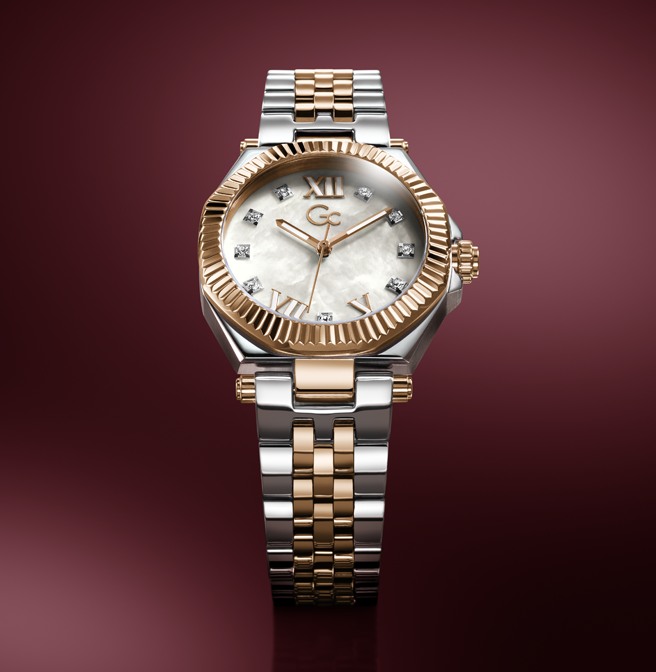 A luxury two-tone wristwatch with a silver and gold-tone metal bracelet, a fluted gold-tone bezel, and a white mother-of-pearl dial with gold Roman numerals and diamond hour markers, set against a dark burgundy background.