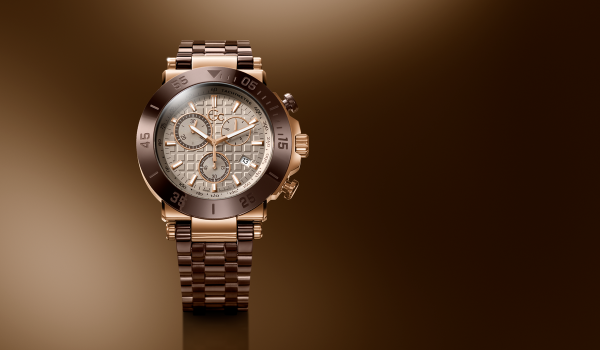 A luxury chronograph watch with a rose gold-tone metal bracelet and case, featuring a textured champagne dial and a dark brown bezel, set against a dark brown gradient background.