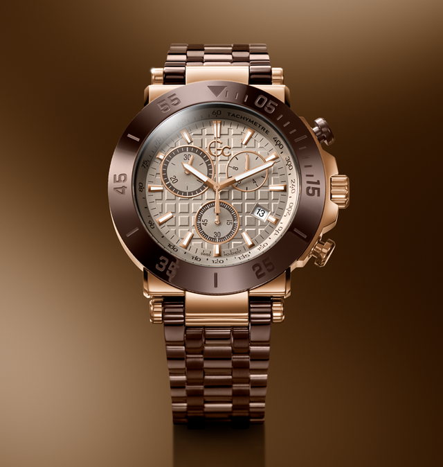 A luxury chronograph watch with a rose gold-tone metal bracelet and case, featuring a textured beige dial with multiple sub-dials and a dark brown bezel, set against a warm brown gradient background.