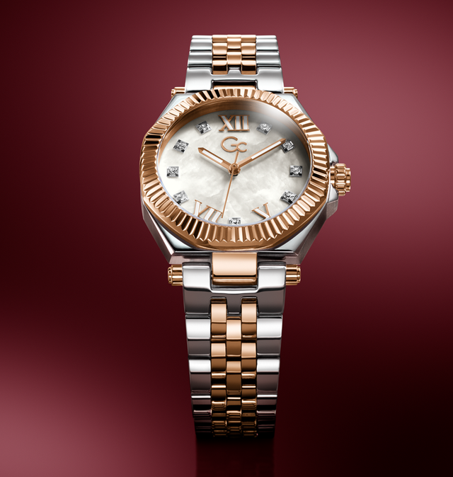 A luxury two-tone watch with a silver and rose gold metal bracelet, a fluted rose gold bezel, and a white mother-of-pearl dial with diamond hour markers, set against a dark red gradient background.