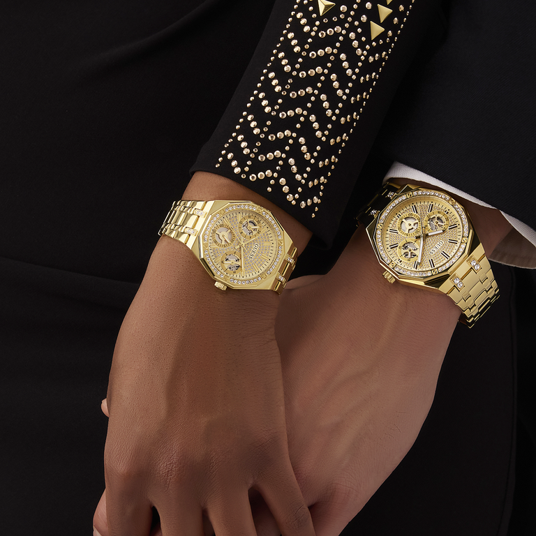 Gold wristwatch on a couple's wrist with a black background
