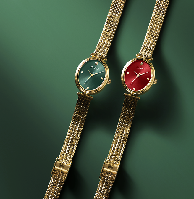 Two petite gold watches with green and red faces on a dark green background
