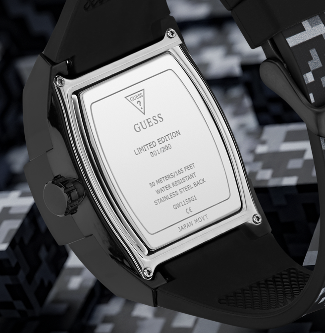 Close-up of the back of a Guess watch with a black rubber strap and a polished silver metal case back, showing engraved text including 'GUESS LIMITED EDITION 01/200'.