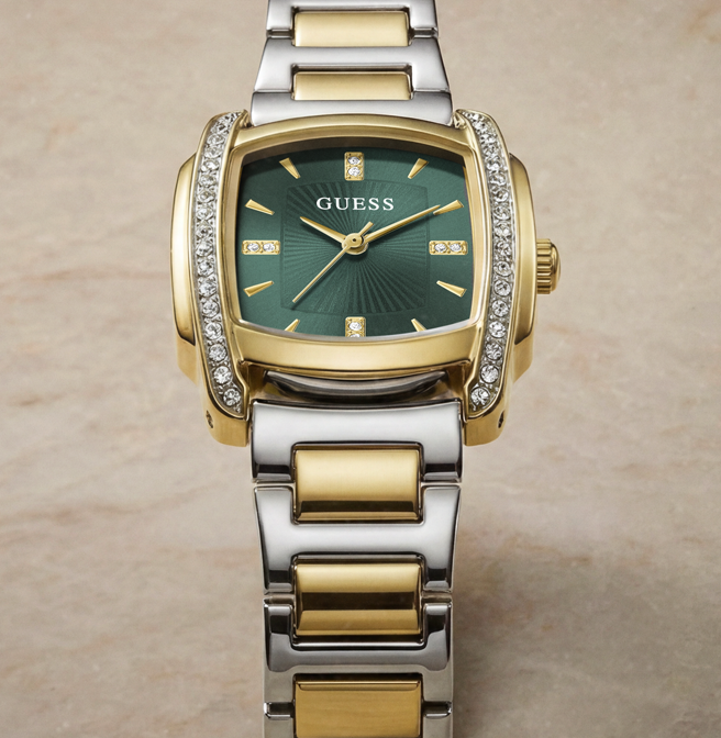 A GUESS women's two-tone watch with a green sunburst dial, gold-tone case, and a silver-and-gold-tone link bracelet, accented with crystal-studded bezels.