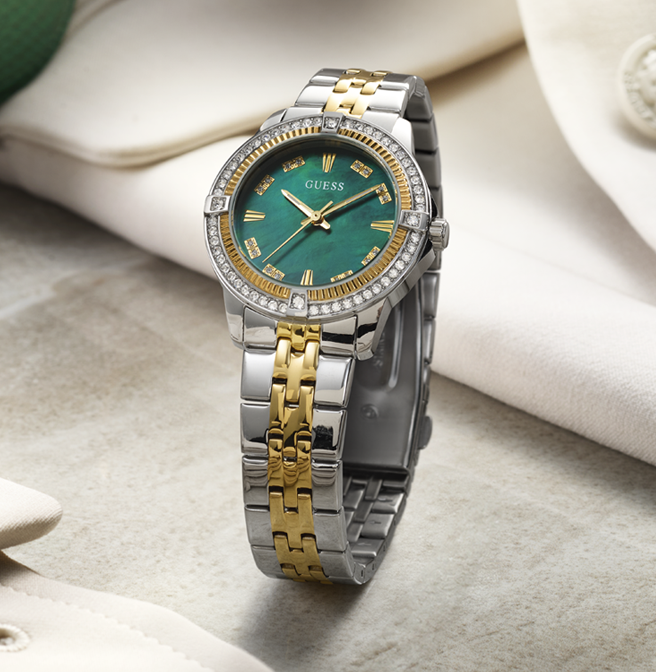 Two-tone silver and gold watch with a green dial on a light background