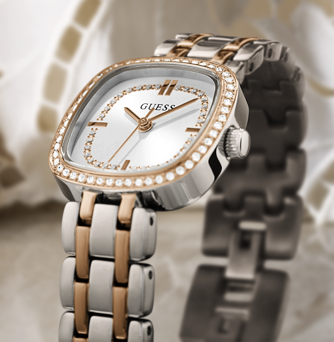 Guess watch with silver and rose gold band on a textured surface