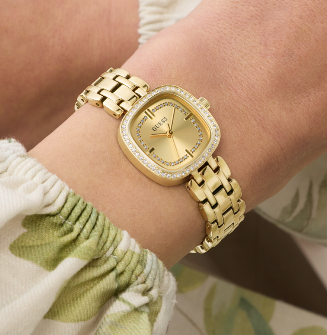 Gold watch on a wrist with a blurred background