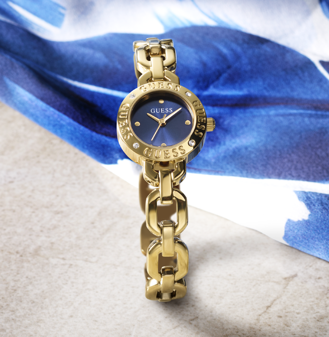 Gold chain-link watch with blue face on a blue fabric background