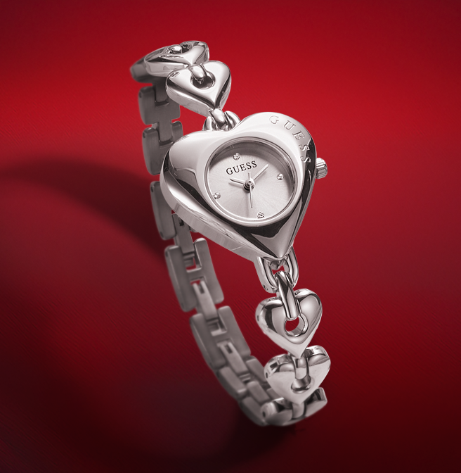 Silver heart-shaped Guess watch on a red background