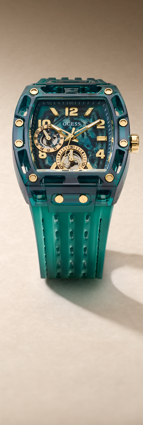 A Guess Oblique watch featuring a translucent teal resin case and strap, with a skeleton dial showing gold-tone gears and gold-tone accents.