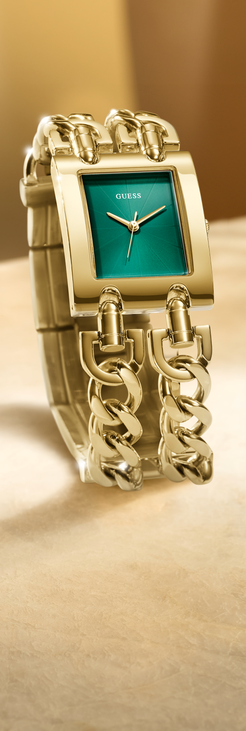 Gold watch with a green face on a beige background