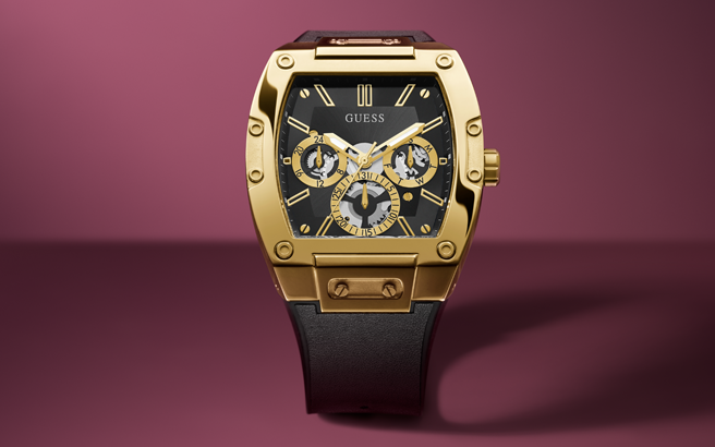 Gold watch with black face on a maroon background