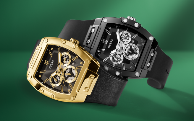 Two Guess watches, one gold and one black, on a green background