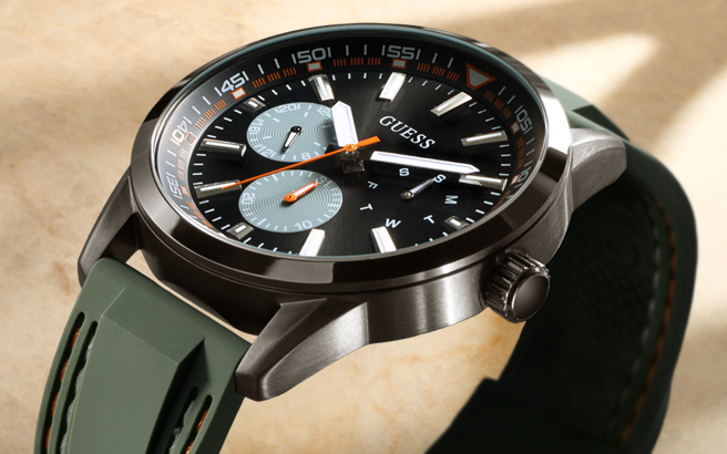 Guess watch with green strap on a beige background