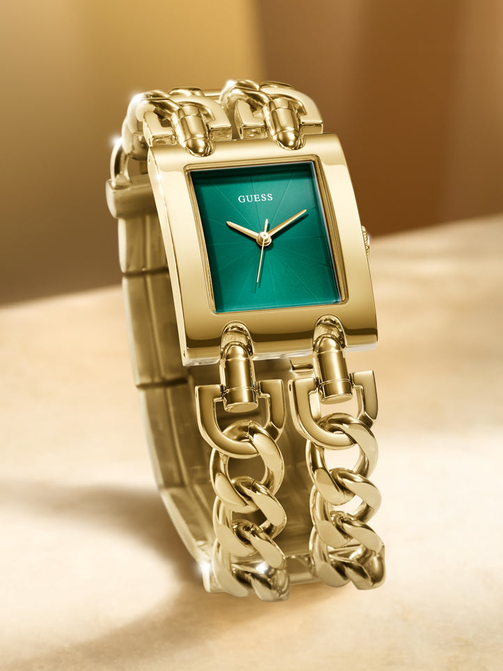 Gold chain-link watch with green face on a beige background